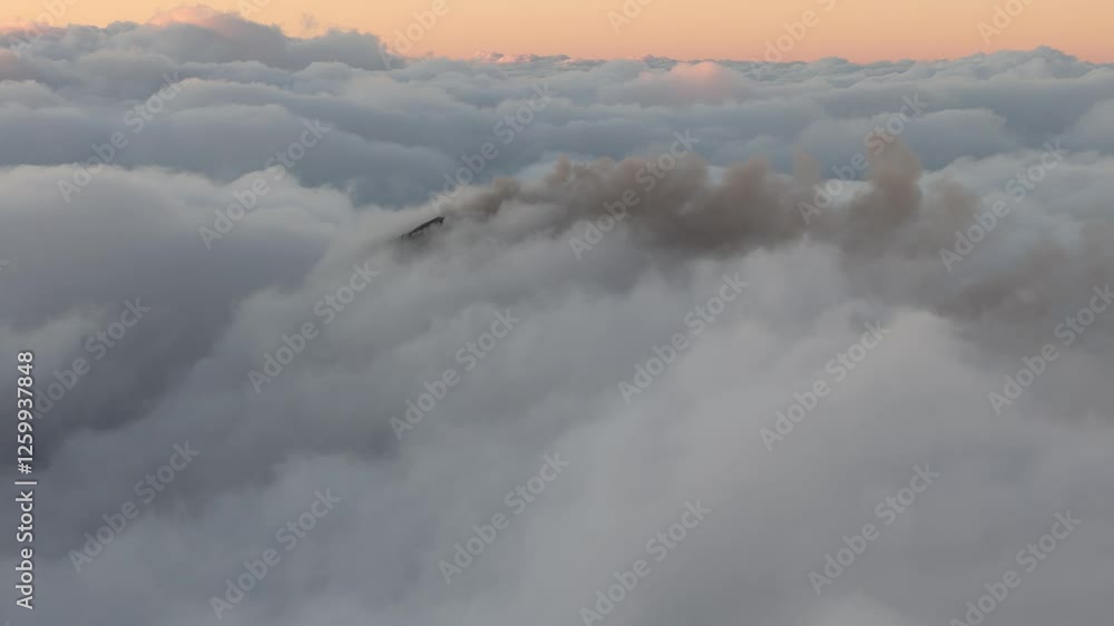 Drone view of Mount Fuego behind thick clouds. An active volcanic crater in Guatemala. Drone view of Mount Fuego behind thick clouds. An active volcanic crater in Guatemala.