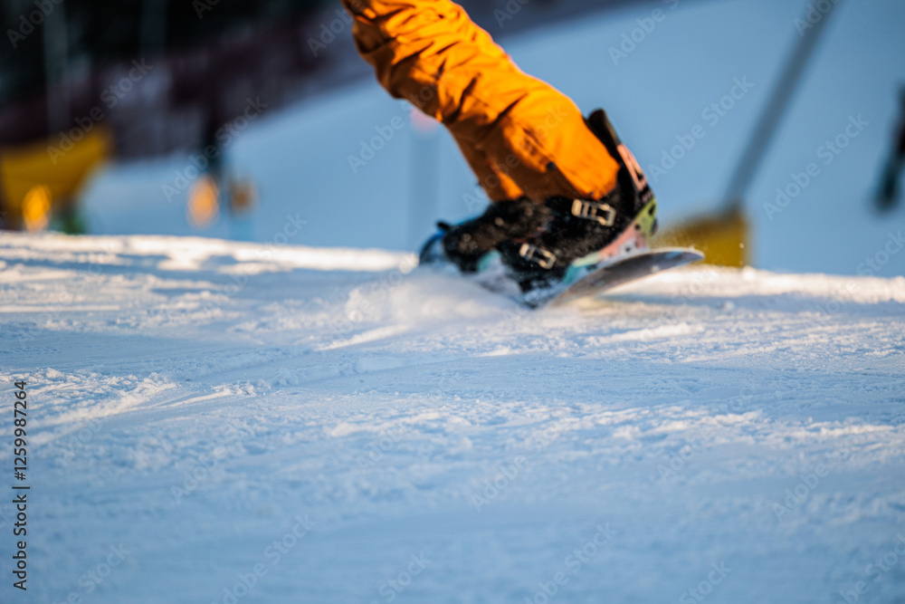 dettaglio di una persona irriconoscibile mentre pratica dello snowboard su una pista da sci, in inverno