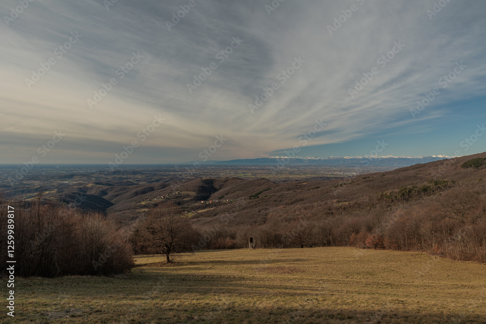 panoramica con vista su un ambiente naturale tra le alte colline della Slovenia occidentale e la vasta pianura dell'Italia nord-orientale, di giorno, in inverno