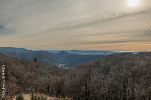 panoramica con vista su un ambiente naturale tra le alte colline e le montagne della Slovenia occidentale, vicino al confine Italiano, di pomeriggio, con cielo leggermente nuvoloso, in inverno