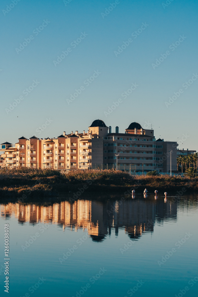 Fototapeta premium Waterfront Buildings Reflected in Calm Lake at Sunset in Spain