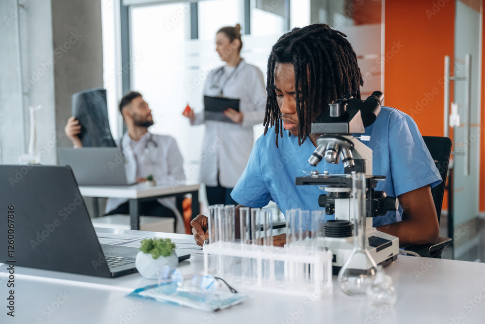 Professional microscope is on the table. Doctors are in the clinic Professional microscope is on the table. Doctors are in the clinic
