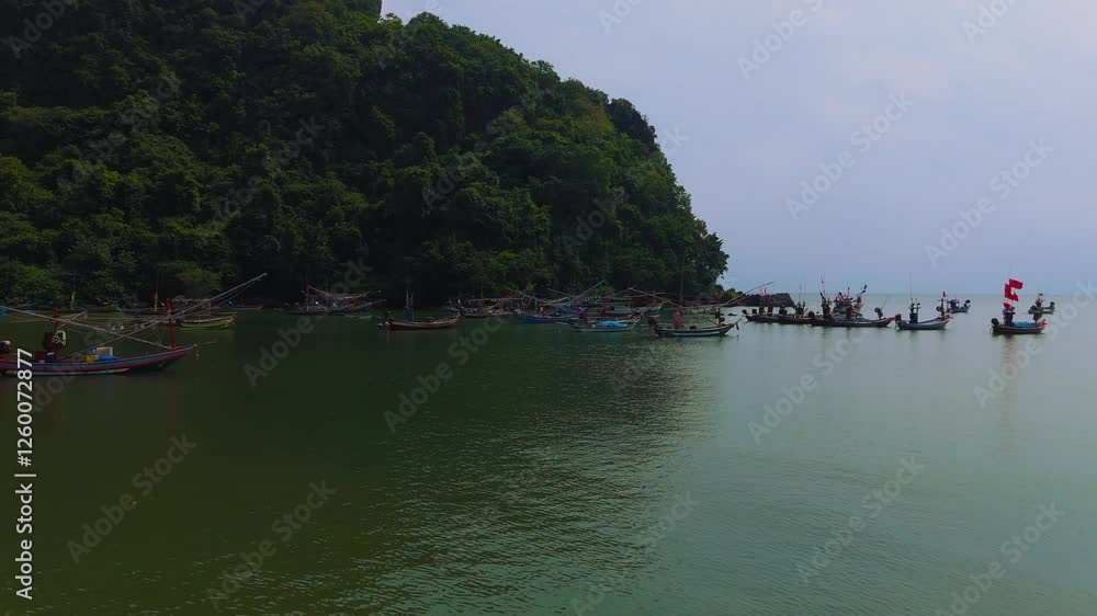 Colourful fishermen boats in a coastal village near Chumphon, Thailand. Clear water, green hills. Aerial Colourful fishermen boats in a coastal village near Chumphon, Thailand. Clear water, green hills. Aerial