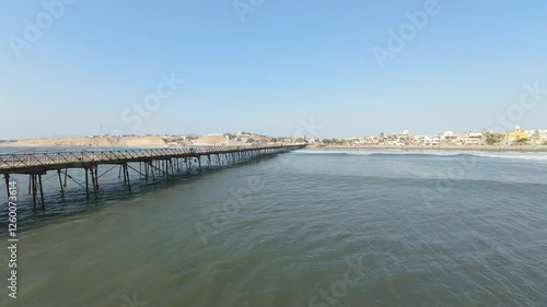 Wallpaper Mural Rustic wooden pier extends over calm blue waters, leading to a vibrant coastal town. Ideal for travel blogs, wall art, or promotional content. Torontodigital.ca