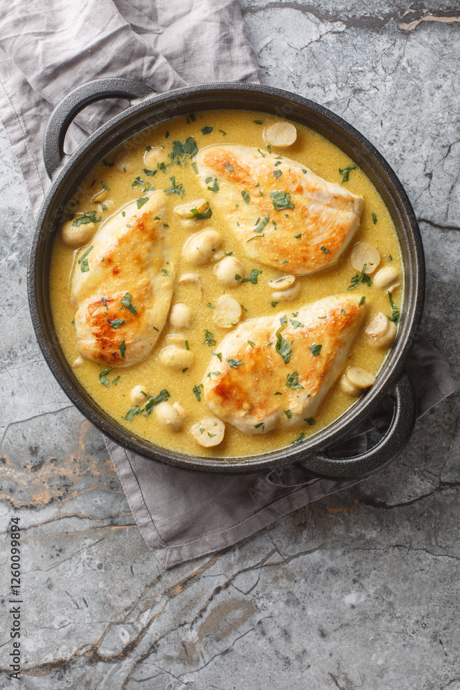 Chicken Diane features brandy, dijon mustard, and heavy cream closeup in the skillet on the table. Vertical top view from above