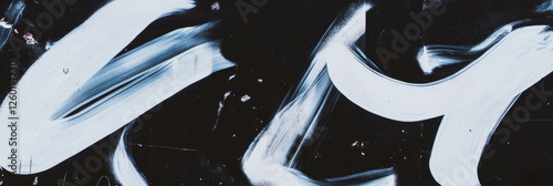 Texture of black wall with dynamic white graffiti markings revealing urban artistry