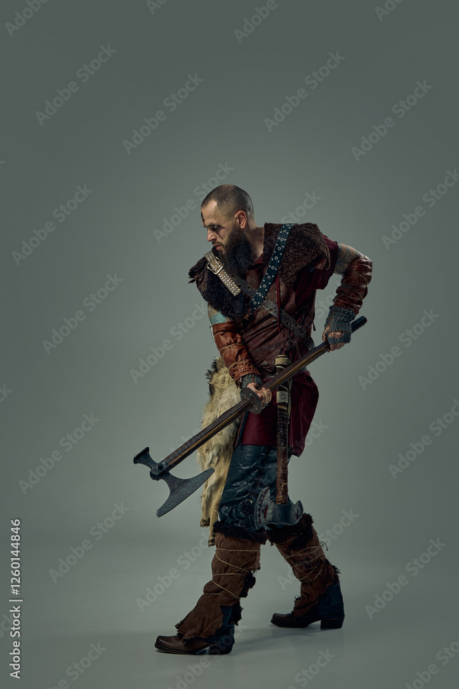 Viking warrior gripping double-headed axe, crouching in battle-ready stance, wearing fur cloak and rugged armor against dark studio background. Concept of medieval battlefield, warrior spirit. Viking warrior gripping double-headed axe, crouching in battle-ready stance, wearing fur cloak and rugged armor against dark studio background. Concept of medieval battlefield, warrior spirit.