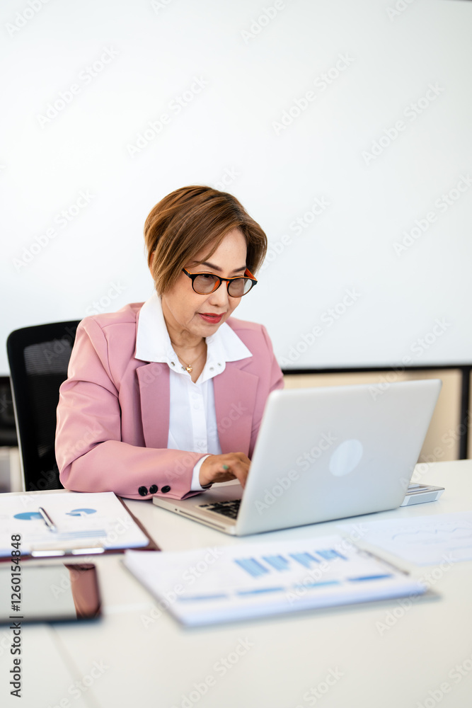 Happy businesswoman professional worker working online doing job on laptop at desk, smiling female employee executive typing message using corporate computer software for business in modern office.