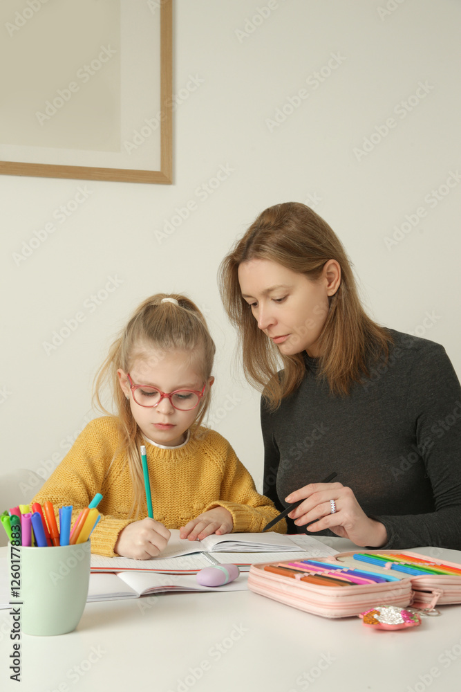 Parental assistance.
Mother helping her little daughter to prepare homework at home. Home education, homeschooling concept. Parental assistance.
Mother helping her little daughter to prepare homework at home. Home education, homeschooling concept.