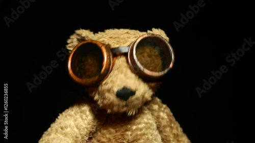 footage of plush bear goggles glasses dark background
 photo