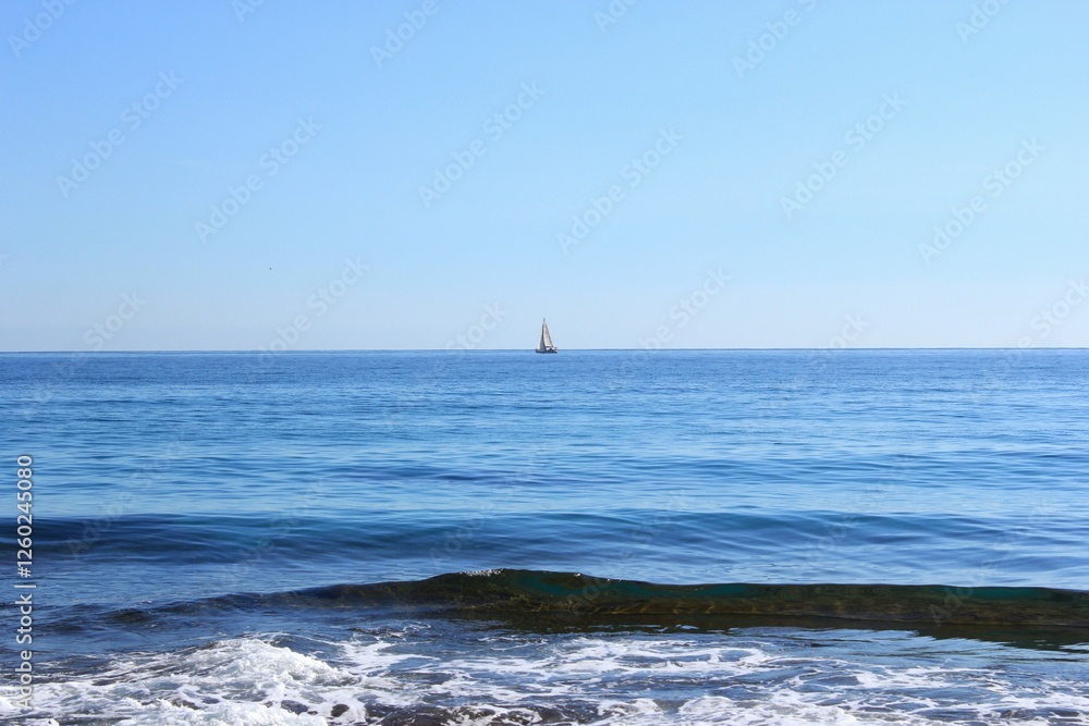 Obraz premium a small white sail boat went out to sea on a clear sunny day