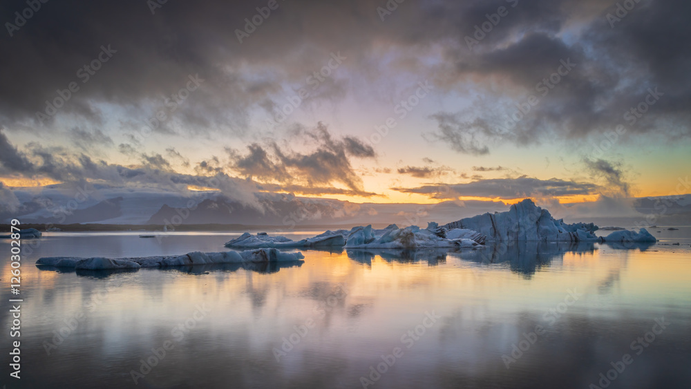 Fototapeta premium Ice chunks floating in Jokulsarlon glacier lagoon in Iceland at sunset