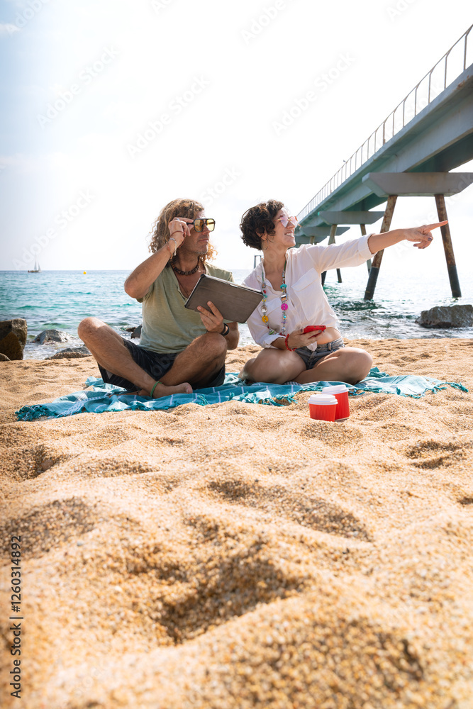 Young couple on vacation on the beach, looking for information about hotels, shopping centers and transport guides. lifestyle and travel concept. Young couple on vacation on the beach, looking for information about hotels, shopping centers and transport guides. lifestyle and travel concept.