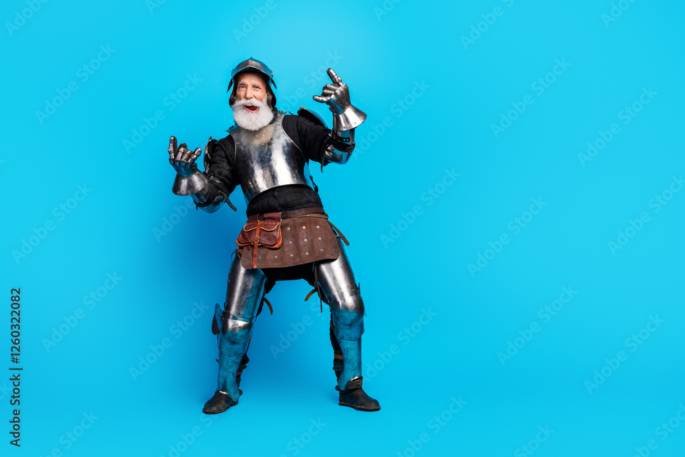 Mature man dressed as a medieval knight in steel armor against blue background Mature man dressed as a medieval knight in steel armor against blue background