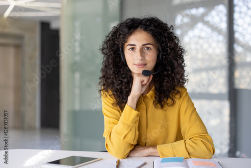 Serious woman with headset looking at camera. Web camera view, online business meeting conference. Support service worker, customer service consulting.