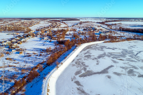 Obraz na płótnie Aerial view of a frozen lake and dam on a sunny winter day w salonie