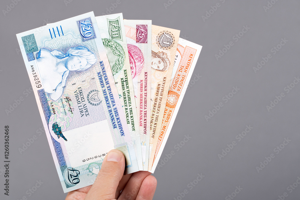 Cypriot pound in the hand on a gray background Cypriot pound in the hand on a gray background