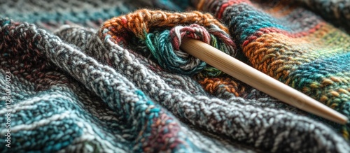 Textile background featuring colorful knitted fabric and wooden knitting needles in intricate patterns and textures. photo