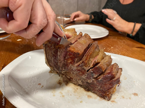 Valokuva cortando una chueta de vaca chuletón de ternera buey asada con sal carne en un p