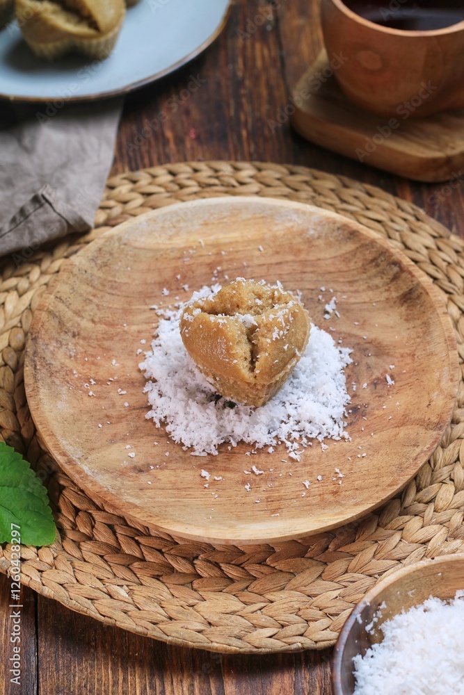 Kue Apam Gula Merah or Kue Apem or Kue Mangkok, Indonesian traditional steamed cake made from brown sugar served with grated coconut on a plate.
Kue Apam Gula Merah or Kue Apem or Kue Mangkok, Indonesian traditional steamed cake made from brown sugar served with grated coconut on a plate.