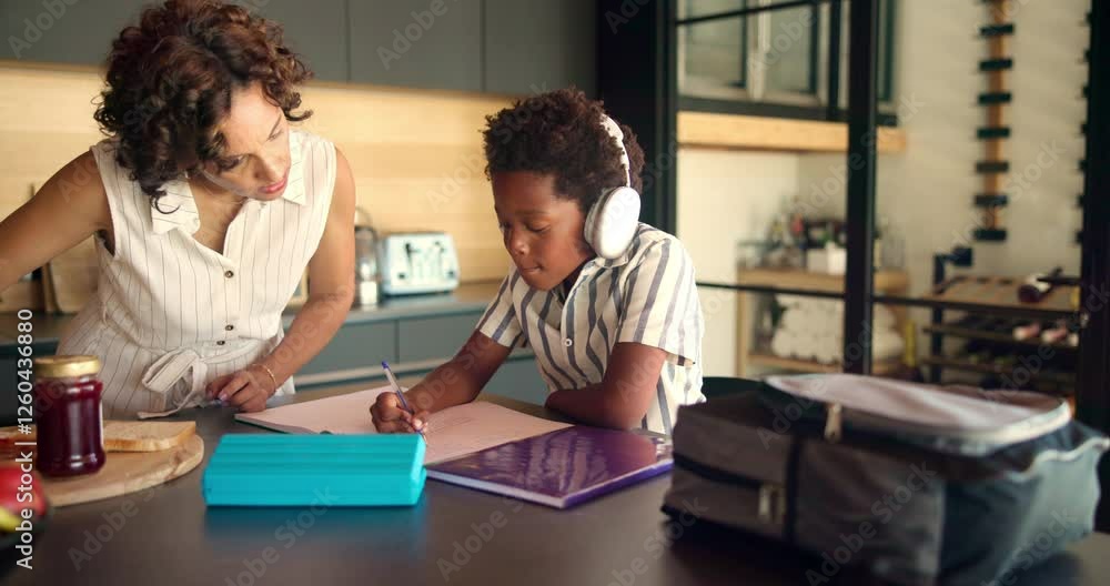 Homework, headphones and child with mom in home for online learning, education and lesson. School, family and African boy with mother with notebook for studying, knowledge and listening to audio Homework, headphones and child with mom in home for online learning, education and lesson. School, family and African boy with mother with notebook for studying, knowledge and listening to audio