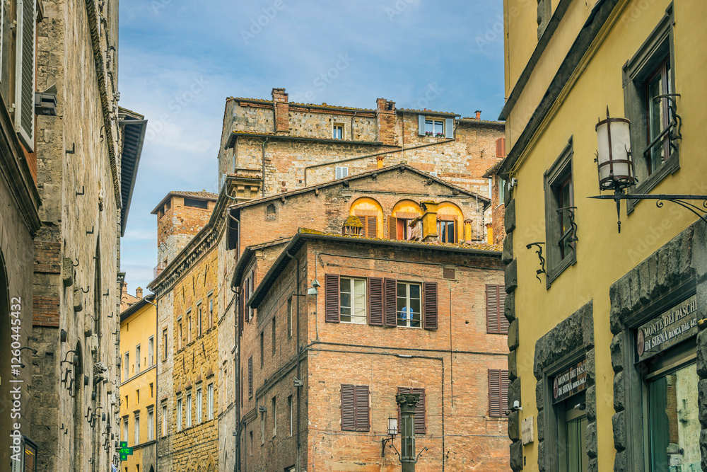 Obraz premium Facade of old buildings in the historical center of Siena, the UNESCO World Heritage Centre, unchanged for 13-14 centuries, with its medieval streets looked like in the early Middle Ages. Italy, 2019
