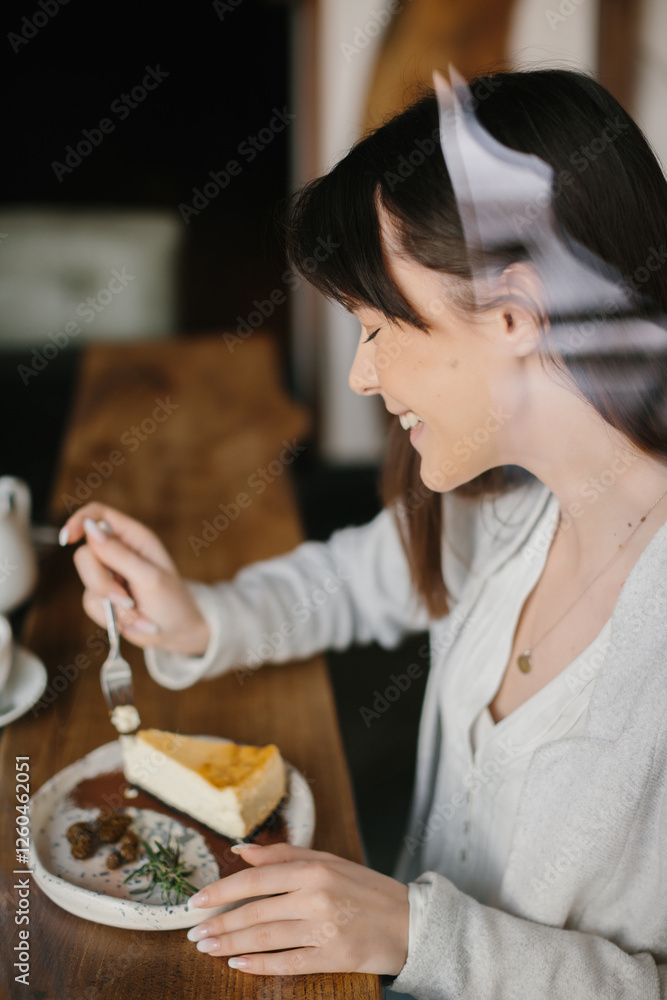 Woman Enjoying a Slice of Cheesecake at a Cozy Cafe Table Woman Enjoying a Slice of Cheesecake at a Cozy Cafe Table