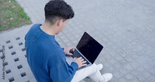Young male using netbook on street