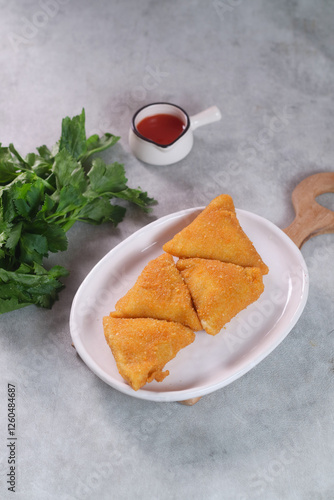 vegetables risoles or risol sayur or risoles sayur stuffed with veggies and enclosed in crepe-like wrappers and rolled into bread crumbs and fried. served on white plate and chili. selected focus
 photo