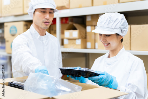 Fotografía 女性、給食、調理、梱包、工場、弁当、弁当屋、箱詰め、検品、宅配食、食品、白衣、給食センター、宅食、配送、配達、笑顔、日本人、ダンボール、プラスチック、容器、倉庫