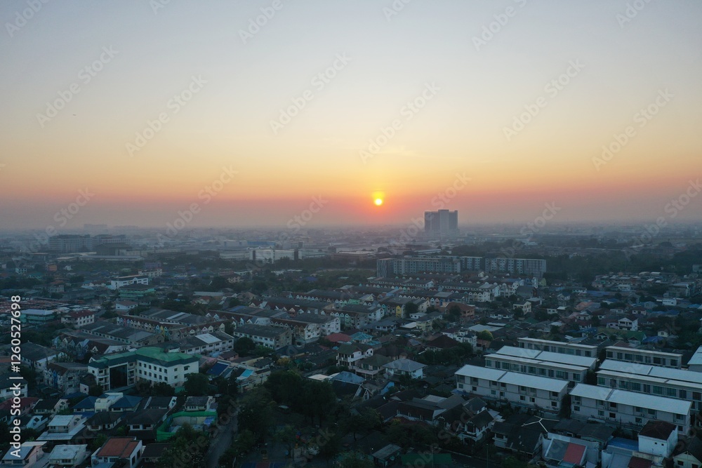 view of sunset city skyline, transportation with cars on Expressway, Road, Roundabout, multilevel junction highway-Top view. Important infrastructure, cloudscape, cityscape, building, crane.
