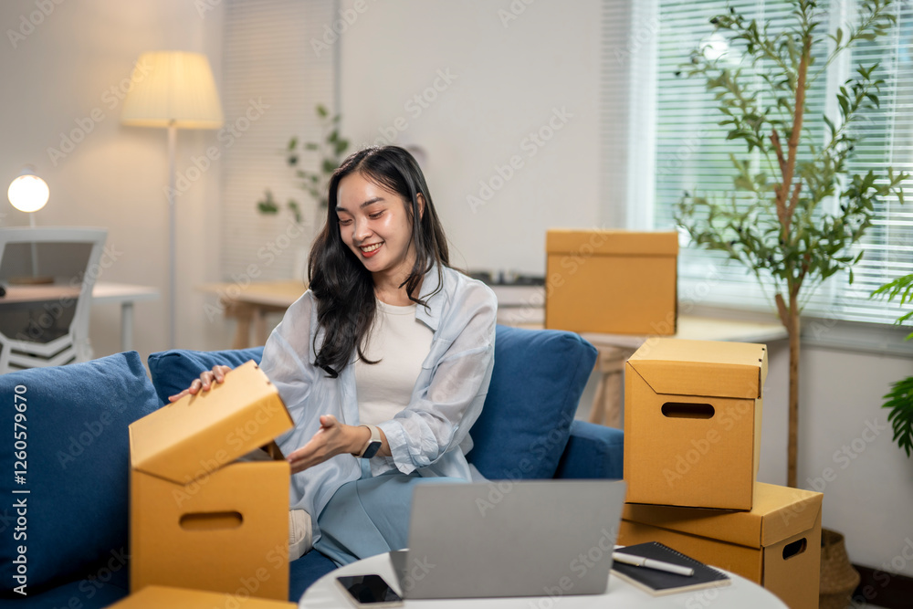A woman sitting on a couch in a room with boxes stacked around her A woman sitting on a couch in a room with boxes stacked around her