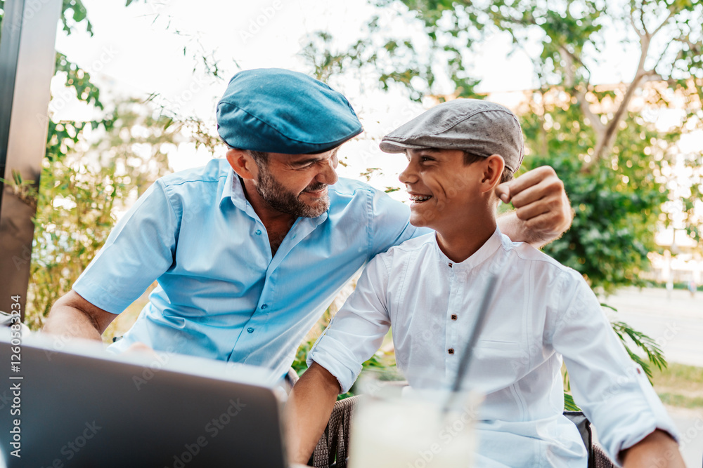 © Dusko - Handsome and happy father and his teenage son sitting in a restaurant and talking. © Dusko - Handsome and happy father and his teenage son sitting in a restaurant and talking.
