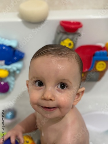 A baby boy playing in the bath photo