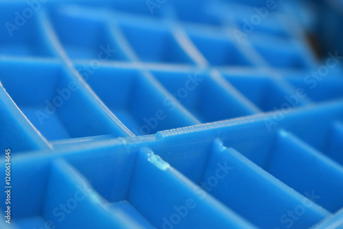 Blue plastic grid with close up view of its geometric pattern