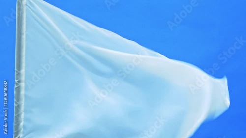 Slow motion video of white flag waving on blue background