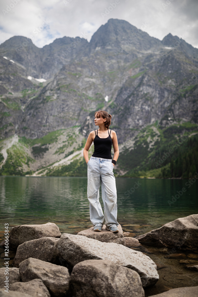 Portrait of beautiful girl standing against beautiful landscape with mountains and rocks.