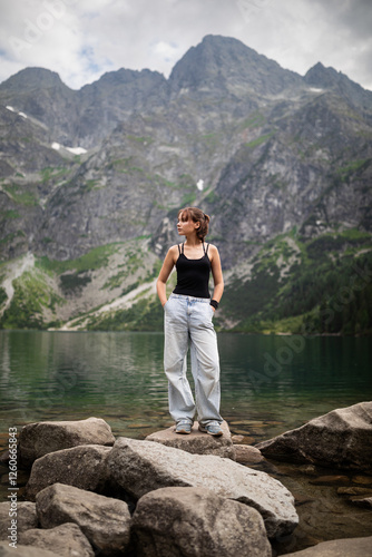 Portrait of beautiful girl standing against beautiful landscape with mountains and rocks.
