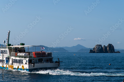 tour boat and rock on the sea photo