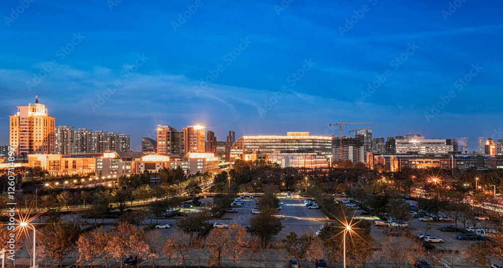 Fototapeta premium Evening Cityscape with Illuminated Skyline