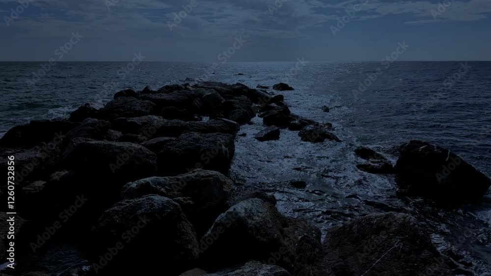 Waves crashing against the seashore at night Waves crashing against the seashore at night