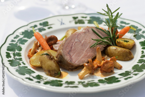 Saddle of veal with potatoes and vegetables photo