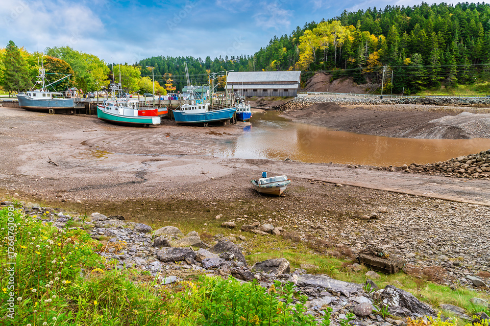 Naklejka premium A view across the inlet past boats moored at low tide at Vaughan Creek, New Brunswick in the fall