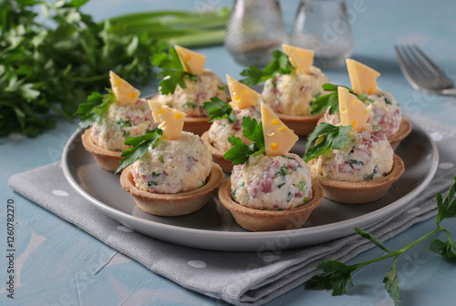 Tableau sur toile Tartlets with sausage and cheese - delicious holiday snack on gray plate