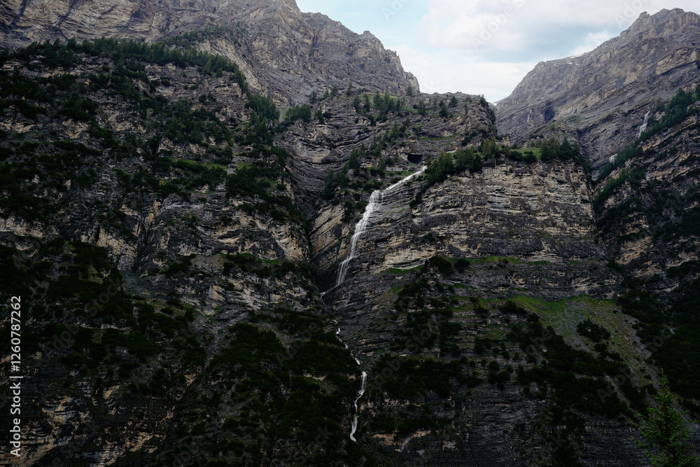 Obraz premium Majestic Mountain Landscape with Cascading Waterfall amidst Lush Greenery..