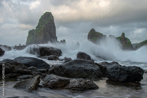 Splashing waves in long exposure shot. Beautiful rocky beach called Keben beach in Blitar, East Java, Indonesia. photo