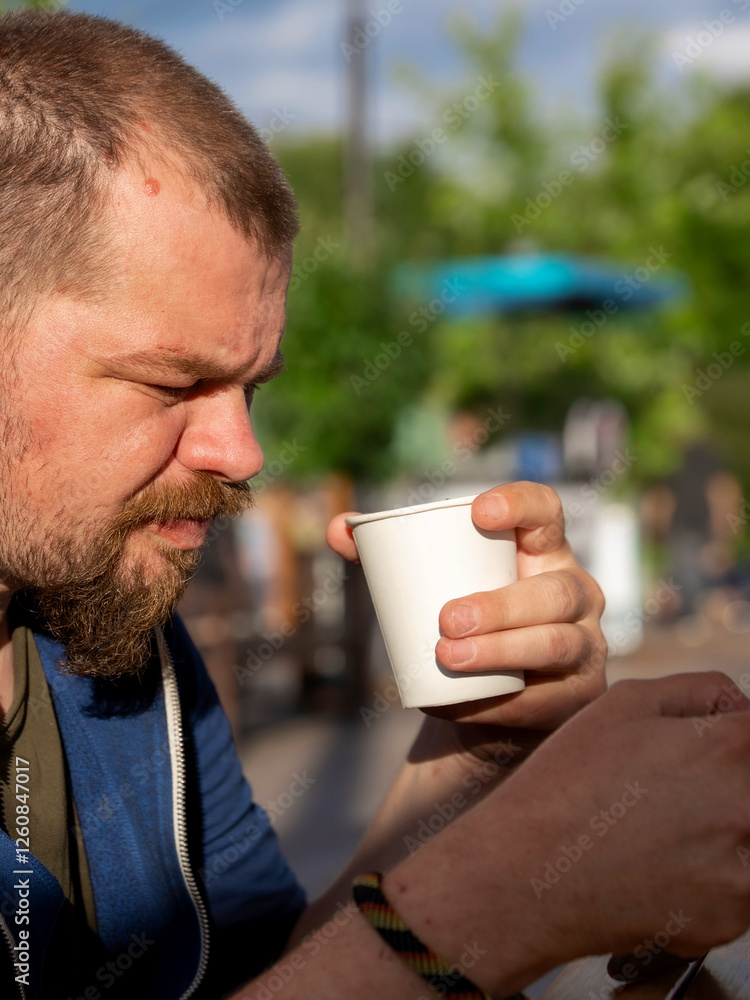 Man with a beard is holding a cup of coffee Man with a beard is holding a cup of coffee