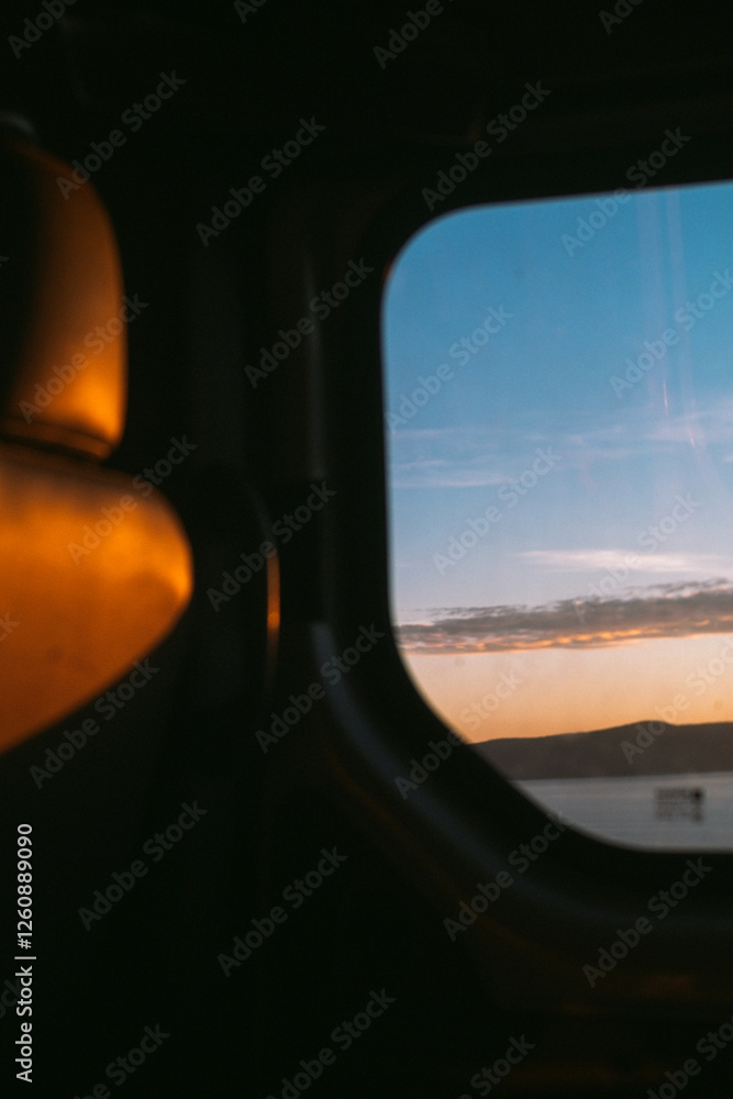 Fototapeta premium Moody roadtrip, car window with a view of sea at sunset
