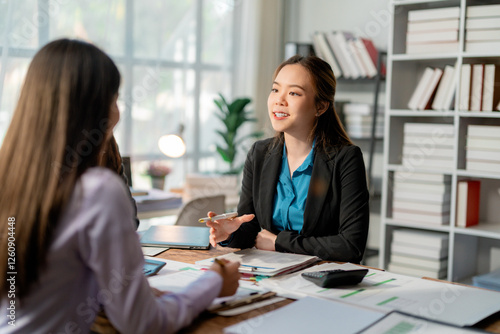 Wallpaper Mural Professional businesswomen collaborating, reviewing sales data on laptop and calculator while analyzing economic growth chart in contemporary workspace Torontodigital.ca