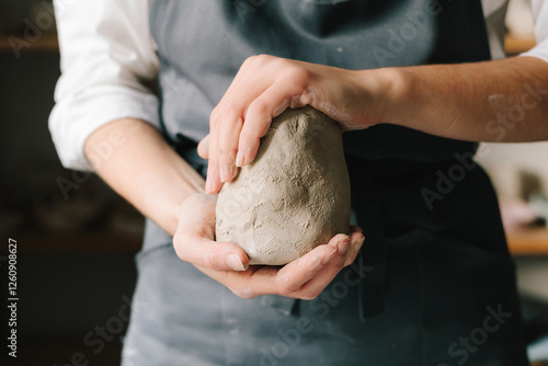 Konstfotografi Potter holds a piece of wet clay in their hands, molds it into form